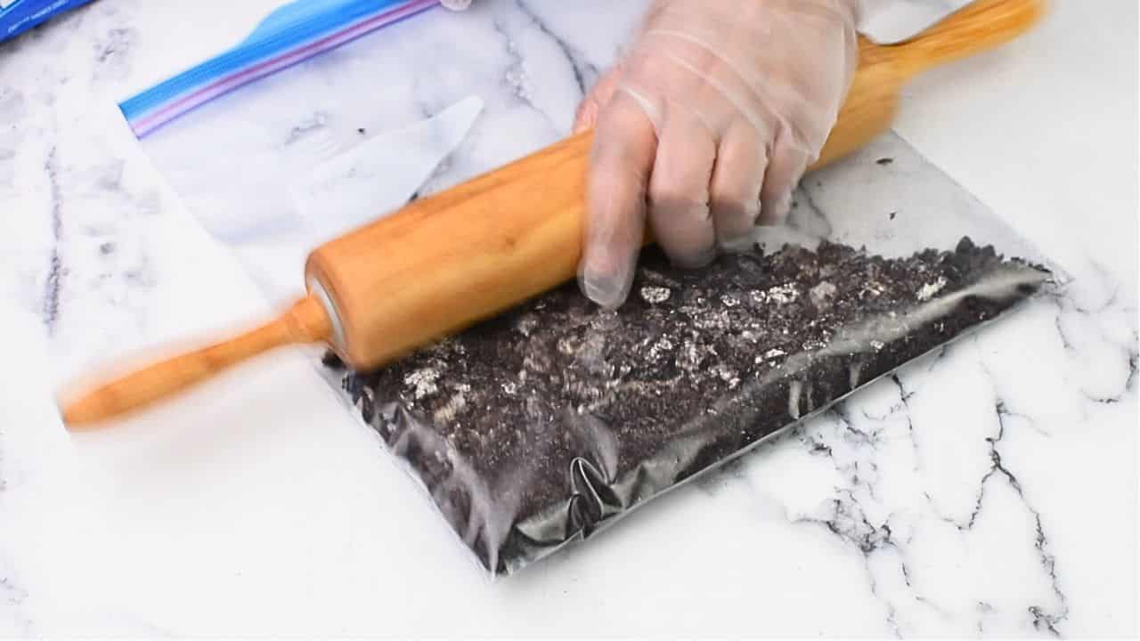 First, crush the Oreo cookies in a plastic bag with either a rolling pin